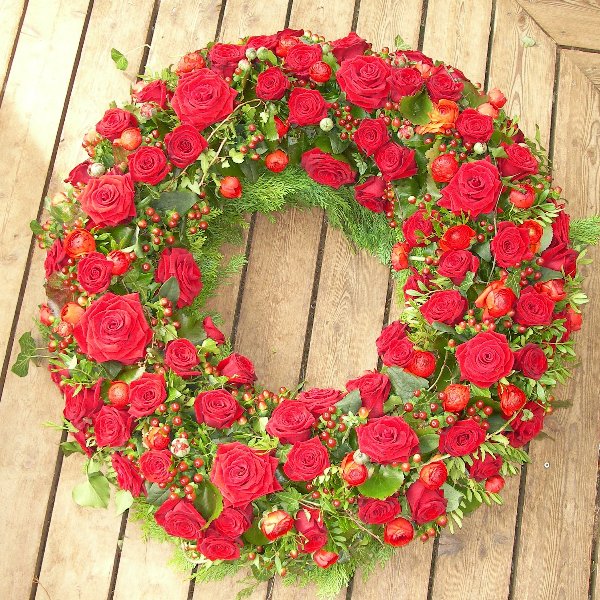 klassischer, rundgesteckter Trauerkranz mit roten Rosen Bild 1